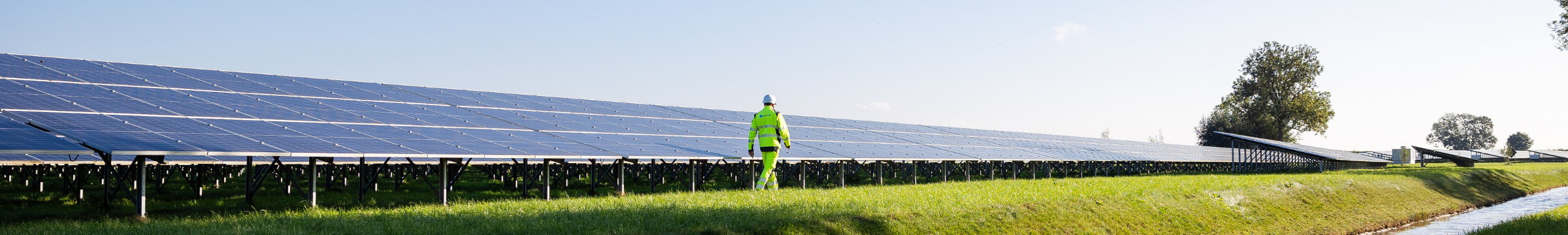 Homme marchant à côté d’un panneau solaire